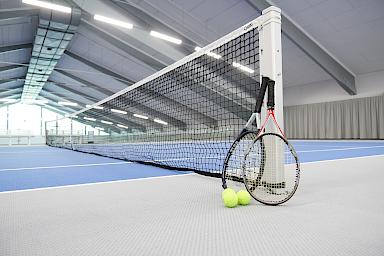Tennishalle mit Tennisschläger am Netz im Wellnesshotel Freizeit In